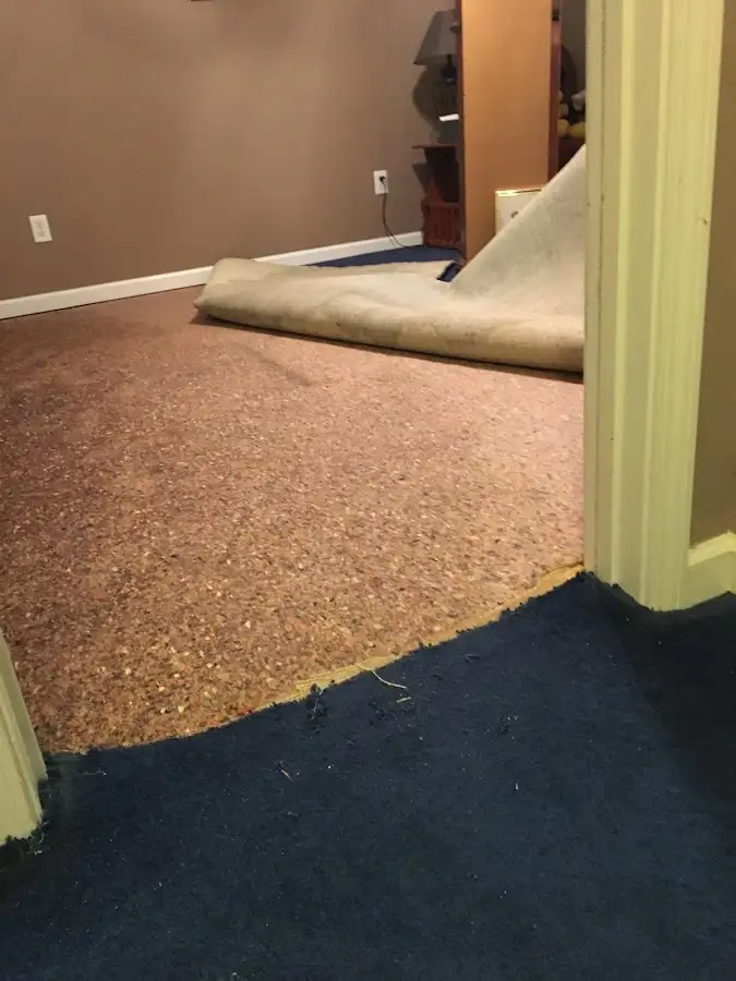 Carpet pad removal revealing water damage during Water Mitigation Services in Country Club Hills